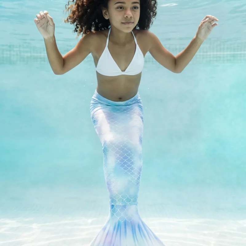 Queue de sirène Bleue Céleste Enfant en mouvement sous l'eau d'une piscine, rayons de soleil