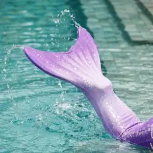 Gros plan dynamique sur la queue de sirène Luna Enfant en action dans l'eau