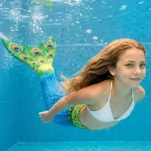 Queue de sirène Mythique Enfant en mouvement sous l'eau d'une piscine, rayons de soleil