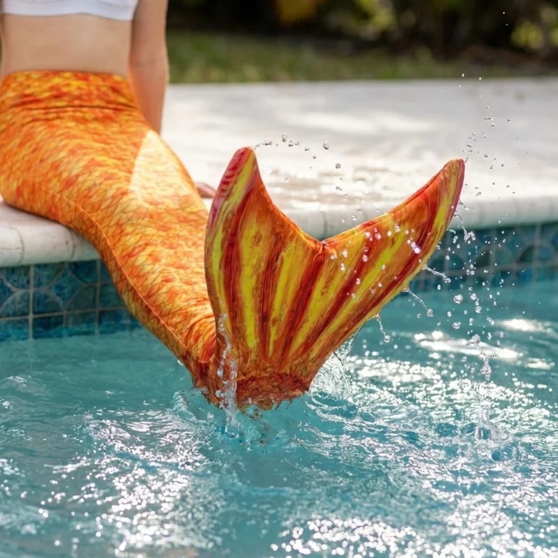 Gros plan dynamique sur la queue de sirène Orange Attina Enfant en action dans l'eau