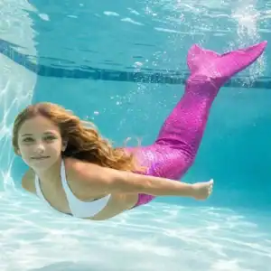 Queue de sirène Rosella Enfant en mouvement sous l'eau d'une piscine, rayons de soleil