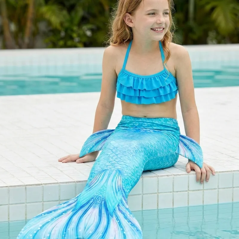 Queue de sirène Atlantica portée par une fillette de profil au bord d'une piscine ensoleillée