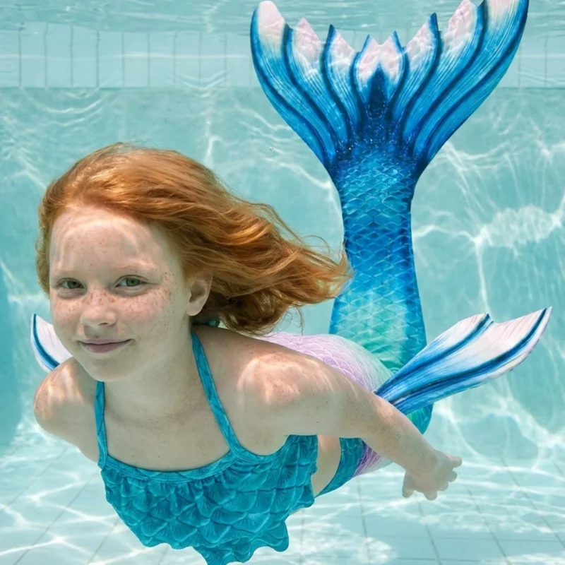 Queue de sirène Bleue Aquaria portée par une fillette en mouvement sous l'eau, rayons de soleil