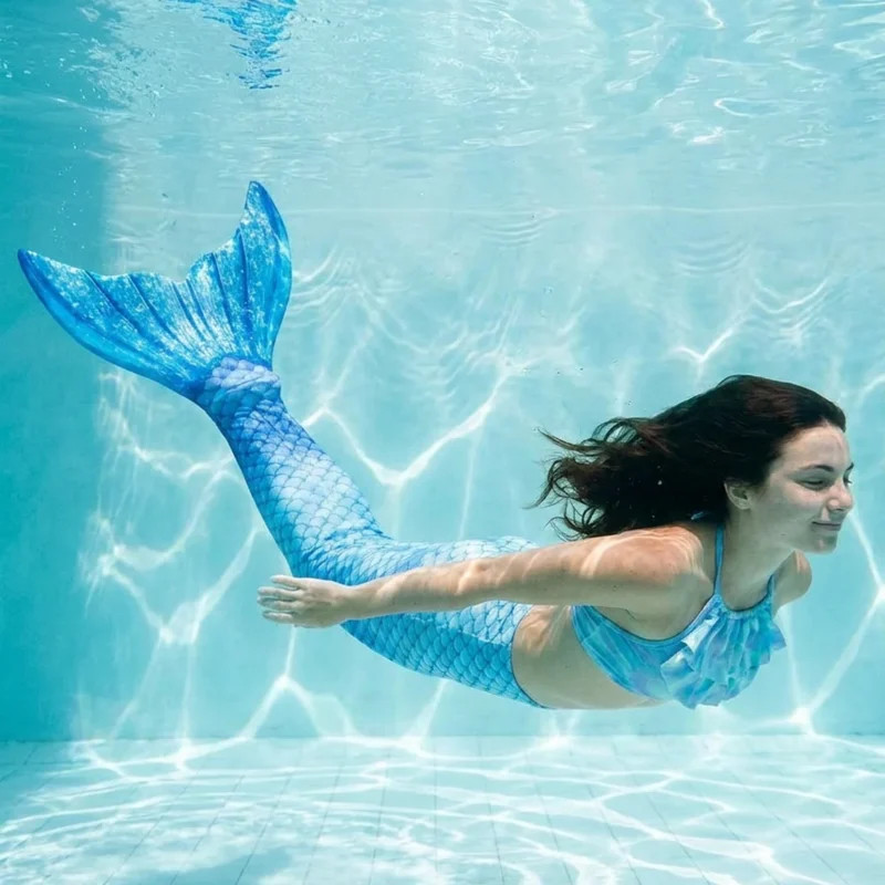 Queue de sirène Azur portée par une jeune femme en mouvement sous l'eau, rayons de soleil
