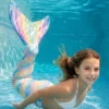 Queue de sirène Multicolore portée par une fillette en mouvement sous l'eau, rayons de soleil